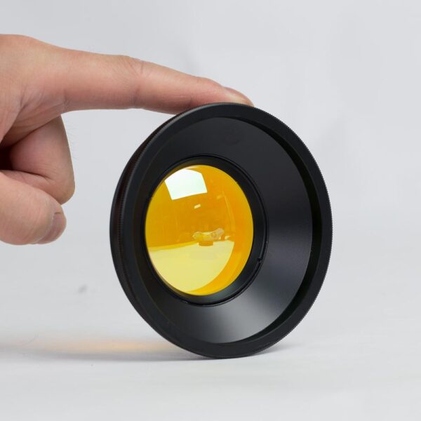 A person holding onto the lens cap of an object