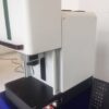 A white machine with a remote control on top of it.